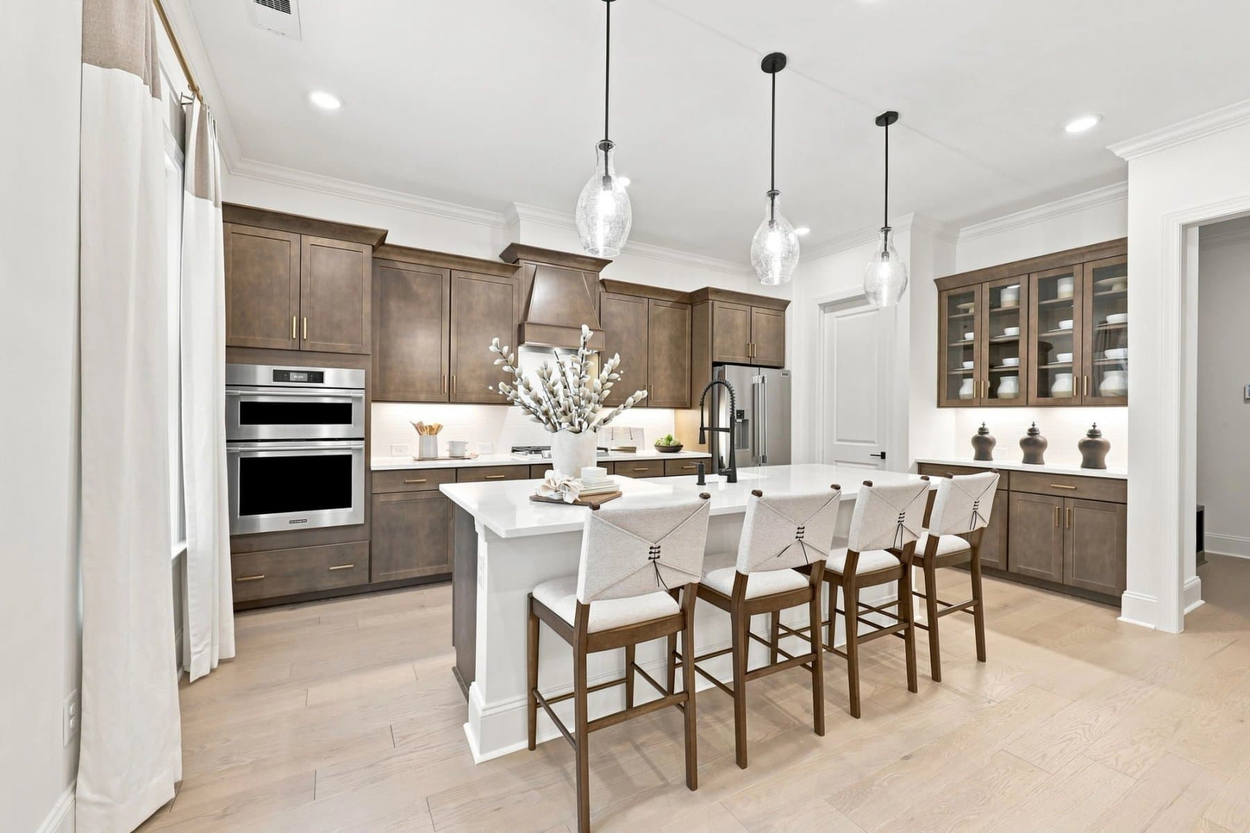 Davidson Homes kitchen with warm wood cabinetry, a spacious island and glass pendant lighting